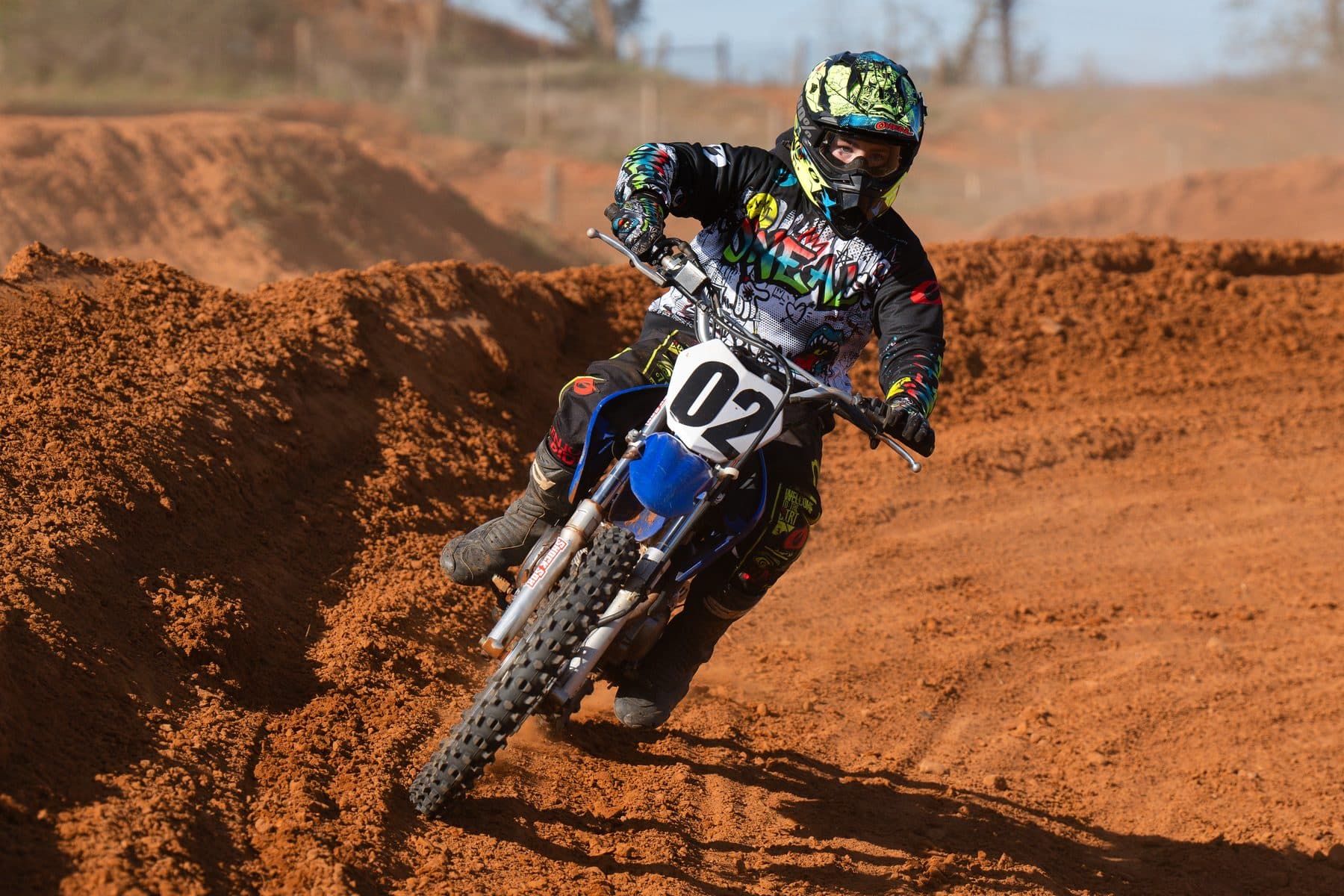 A rider leaning hard through a bermed corner, kicking up dirt on the Cycle Ranch track
