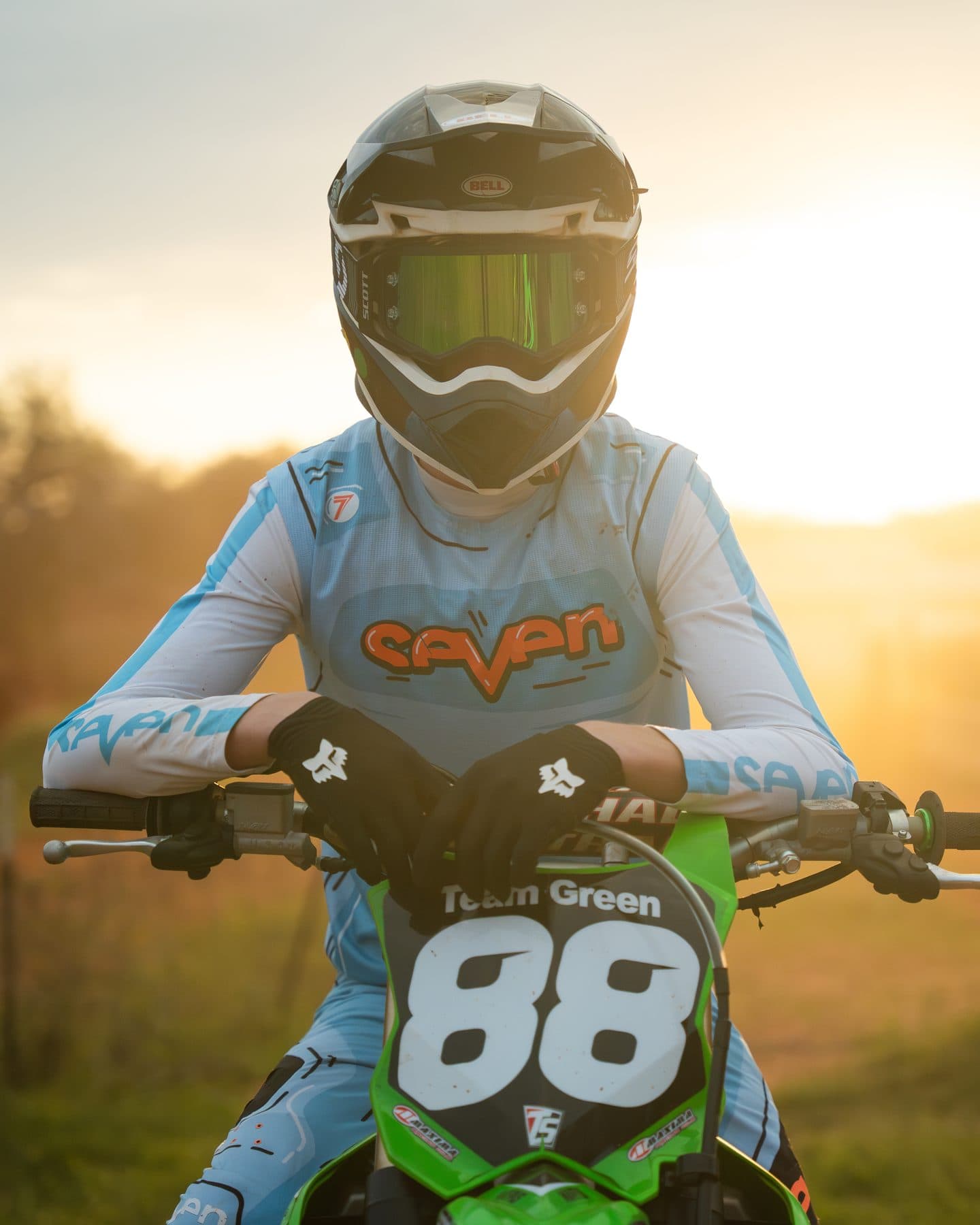 A young rider in full gear on a bike, backlit by a warm Texas sunset at Cycle Ranch